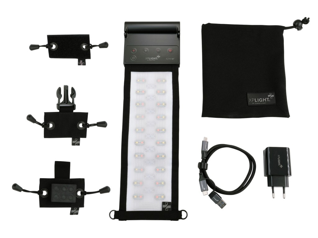 XP ALPHA 2⁺ complete kit on white: flexible LED panel with control head, three mounting bases (Velcro, buckle, magnet), drawstring pouch, USB cable and wall charger