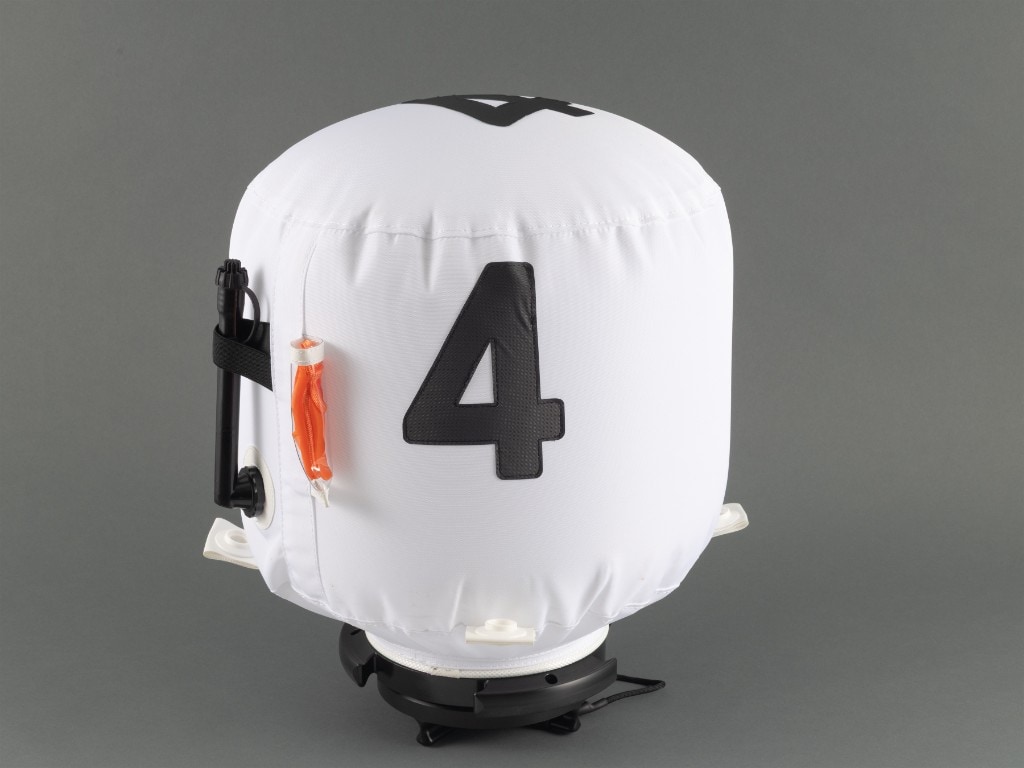 XP FROQ inflatable marking buoy on a neutral grey background: white fabric cover with bold black number 4, black base mount, side valve and orange accessory in a clear sleeve